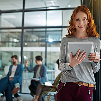 Frau iPad rothaarig – © PeopleImages / iStock.com