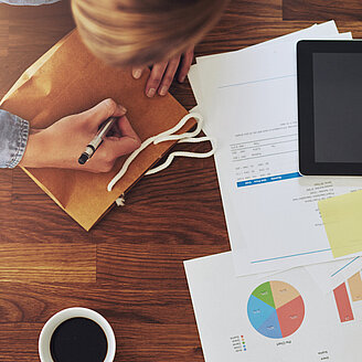 Junge Unternehmerin arbeitet an Schreibtisch – © langstrup / 123RF